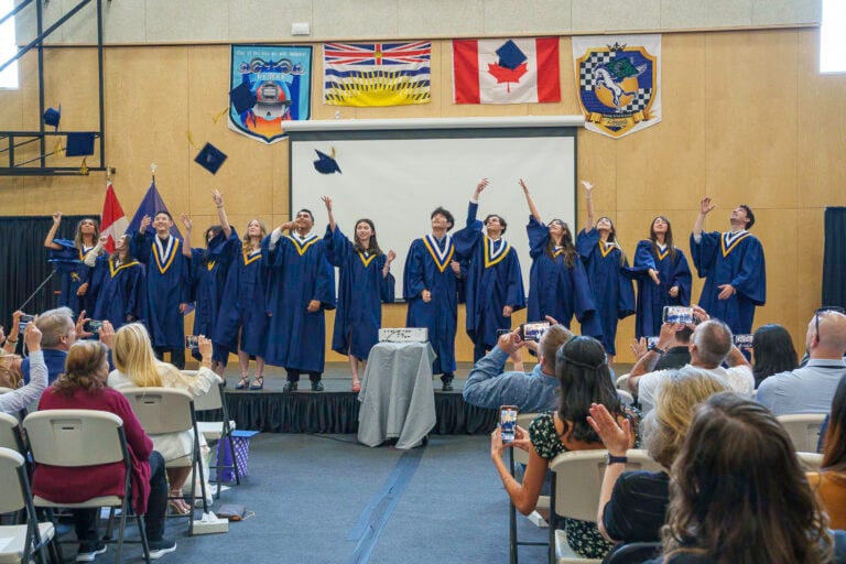 Urban Academy class of 2025 tossing their caps in the air at commencement.